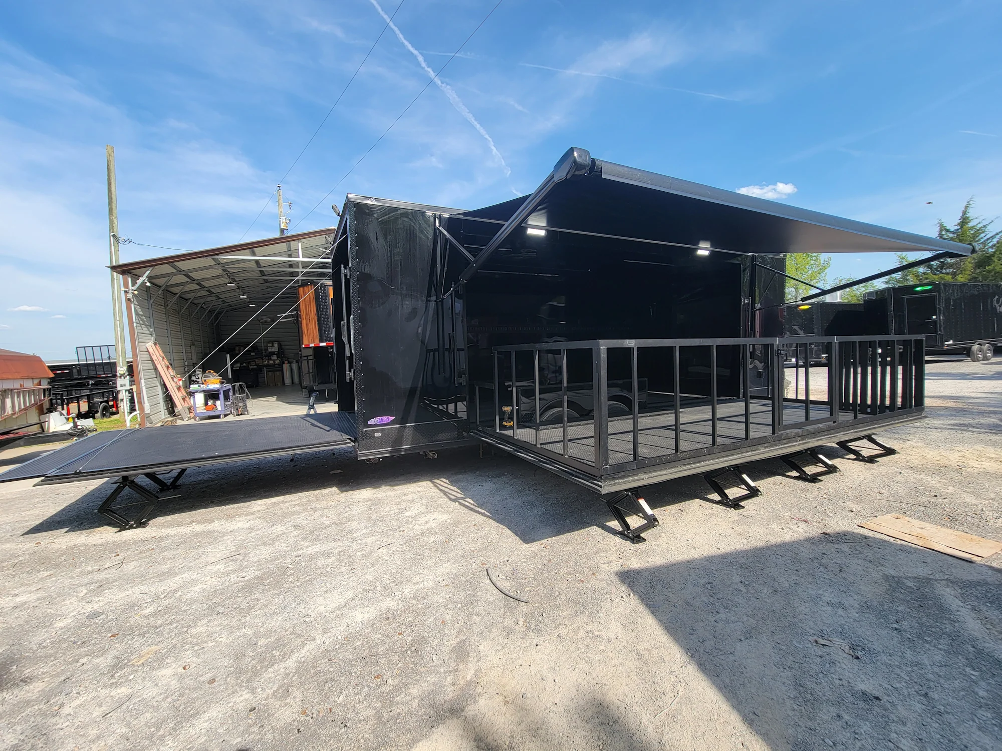 645-8.5-x-24-black-with-blackout-stage-trailer-with-awning-semi-screwless-exterior-5.webp 8.5' X 24' Black With Blackout Stage Trailer With Awning Semi Screwless Exterior